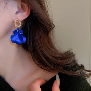 Detail shot of Klein blue layered petal earrings with golden textured round studs