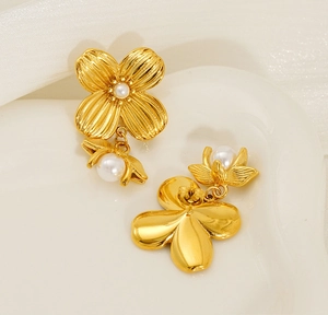 Macro detail of gold flower pearl earrings with radial textures and drop pearl charms