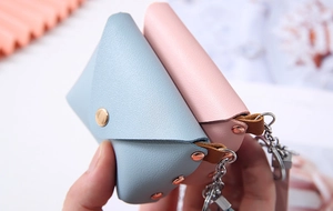Macro detail of PU leather mini coin pouch featuring rose gold snap and key ring