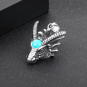 Macro shot of silver dragon head pendant with turquoise stone inlay for men