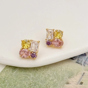 Macro shot of luxury earrings featuring colorful zircons and golden plating details