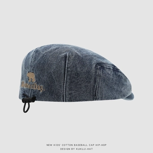 Dettaglio del berretto in denim per bambini con ricamo orsetto e coulisse elastica nera