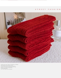Close-up of five pairs of red chunky knit socks with warm wool texture in a cozy stack