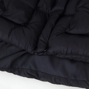Black hooded puffer jacket with warm padding and durable zip detail in minimalist style