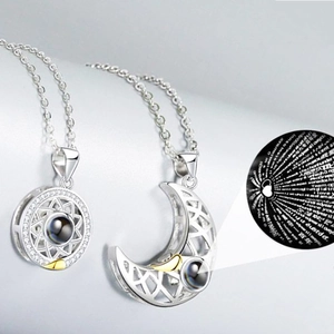 Detail of sun and moon magnetic necklaces showing 100 languages I love you projection