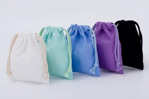 Detail showing five colored drawstring cotton bags in white, green, blue, purple, and black
