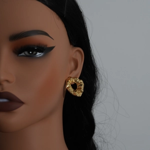 Close-up of gold irregular textured hoop earrings worn on a model side profile