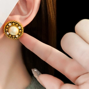 Gros plan de boucles d'oreilles vintage en perles et diamants portées par un mannequin