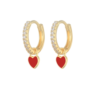 Macro shot of gold hoop earrings with sparkling cubic zirconia and red heart enamel charms