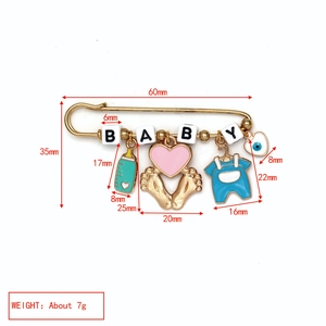 Detailed view of baby themed brooch with measurements showing blue romper and evil eye charms