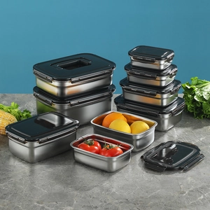 Set of stainless steel food storage containers with black airtight lids on marble surface