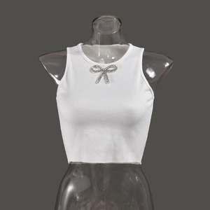 Detail of white ribbed crop top with sparkling rhinestone bow embellishment