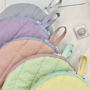Detailed view of quilted shell cosmetic bags in various soft macaron colors