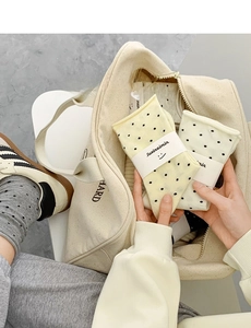 Detailed view of beige and pale yellow polka dot cotton socks in a canvas bag