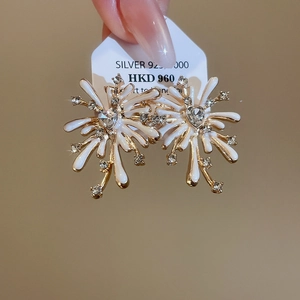 Detailed macro view of 925 silver firework studs with white enamel and heart crystal