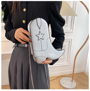 Detailed view of silver western boot bag with star stitching and delicate chain strap