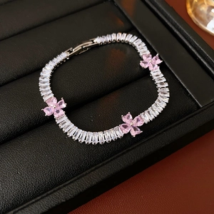 Macro shot of silver-plated bracelet with pink heart-shaped zircons and floral details