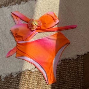 Détail d'un bikini dégradé à taille haute avec une fleur d'orchidée 3D sur le haut bandeau