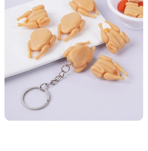 Macro shot of 3cm mini roast chicken keychain with detailed texture on a white plate