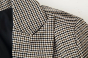 Detail shot of notched lapel and textured houndstooth fabric on a tailored blazer