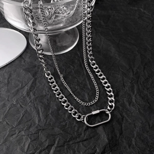 Detailed close-up of double-layer silver curb chain necklace with oval carabiner buckle