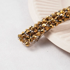 Vue macro de perles de cristal facettées sur une barrette en métal doré sur coquillage