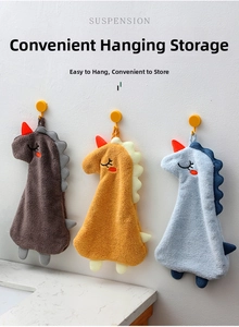 Three colorful dinosaur hanging hand towels in a bathroom setting with orange loops