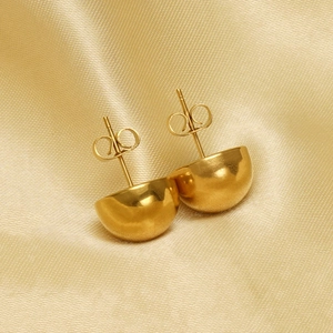 Polished gold semi-sphere stud earrings with minimalist design on champagne satin