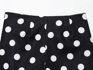 Detail of high waist polka dot shorts with invisible zipper and smooth black fabric