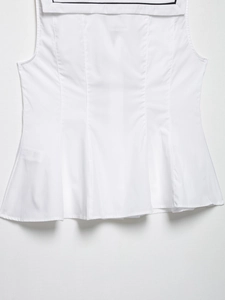 Detail view of white sleeveless top featuring a distinctive navy collar and bow contrast