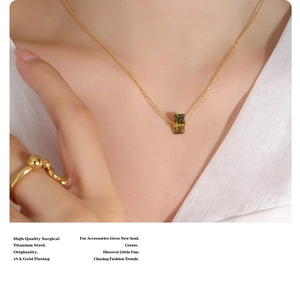 Close-up of 18k gold plated surgical titanium steel necklace with green-brown pendant