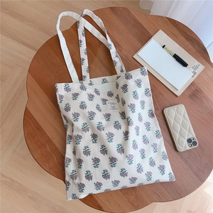 Detail of floral canvas tote bag with purple prints on a vintage wooden table setting