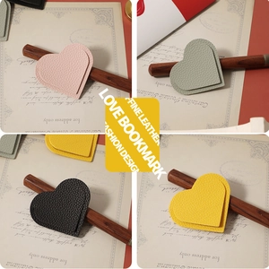 Macro detail of heart-shaped leather bookmarks in pink, green, yellow, and black
