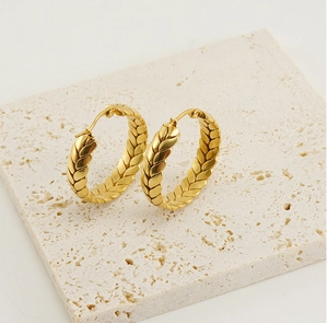 Macro view of 18K gold stainless steel hoop earrings with wheat grain texture