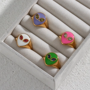 Detailed shot of gold-plated alien rings with colorful enamel and inset gemstones