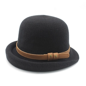 Detail of black bowler hat featuring a brown leather strap and vintage metal rivets