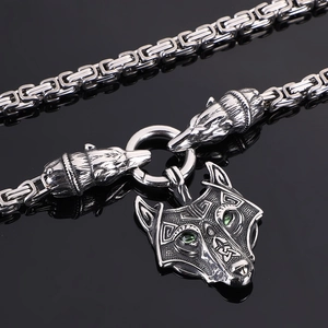 Detail of Viking wolf head pendant with green eyes on stainless steel chain
