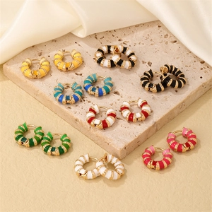 Bohemian style colorful enamel hoop earrings with gold spiral texture on travertine
