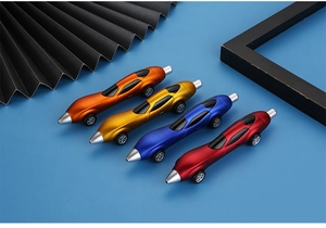 Detail view of four colorful racing car shaped ballpoint pens on a blue surface