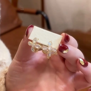 Gros plan détaillé des boucles d'oreilles fleurs en zircon doré au design à quatre pétales