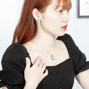 Détail de la parure collier et boucles d'oreilles en argent avec perle sur mannequin