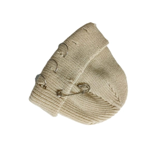Detail of beige knit beanie featuring punk style metal rings and silver safety pin accessory