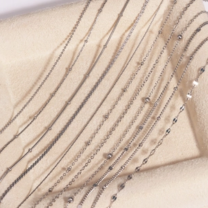 Close-up of various silver stainless steel chain styles including box and snake links