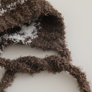 Macro view of plush jacquard texture and strap on this winter warm earflap hat