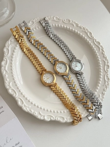 Close-up of three elegant women's watches with mother of pearl dials on a vintage plate
