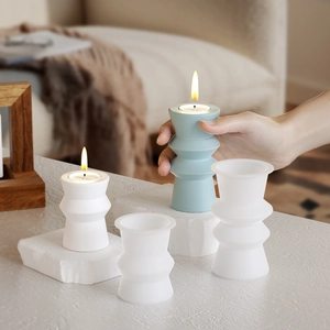Macro view of geometric cylindrical resin candle holders in blue and matte white finish