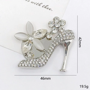 Elegante spilla a forma di scarpa col tacco argento con strass e petali bianchi