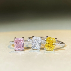 Detailed view of three rectangular radiant cut zircon rings in pink white and yellow