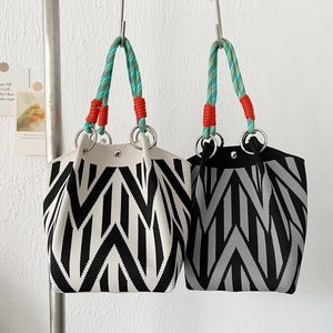 Elegant knit handbag with zigzag patterns and colorful rope handles for a modern look