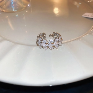 Close-up of silver rotating snowflake ring with zircon inlay on a white porcelain base